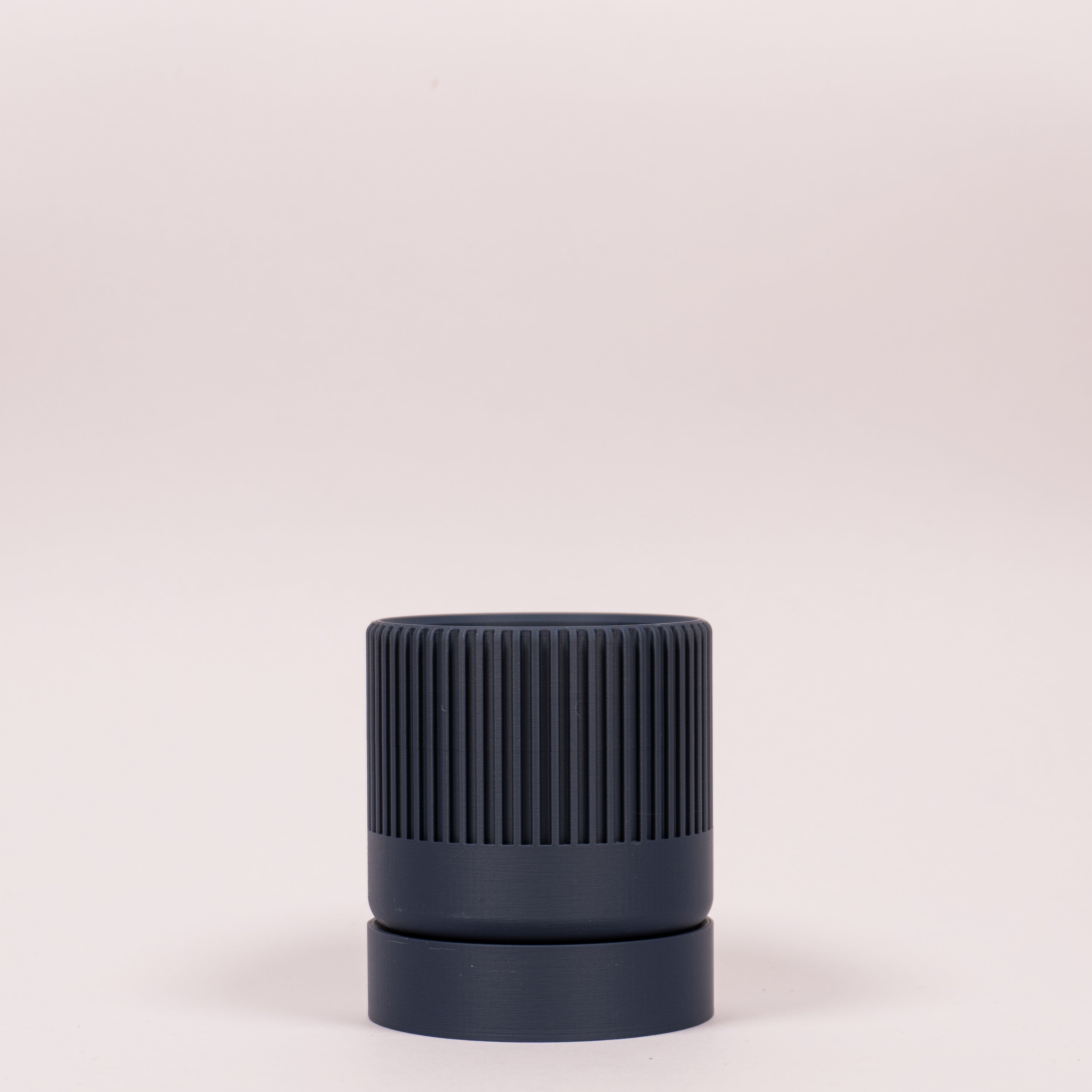 En blå seedling urtepotteskjuler i størrelsen Ø6cm med en hvid baggrund