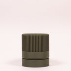 Billede af en grøn Seedling urtepotteskjuler Ø6cm stående oprejst i en ren billedboks med hvid baggrund. Viser det rolige design i bioplast.