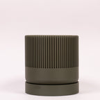 Frisk grøn Seedling urtepotteskjuler Ø9cm. Billedet er taget i en lys, minimalistisk opstilling, der fremhæver den naturlige farve.