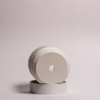 Nærbillede af en hvid Seedling urtepotteskjuler Ø6cm, lagt på siden i den matchende drypbakke på en hvid baggrund, der tydeligt viser drænhullerne i bunden.