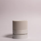 Billede af en hvid Seedling urtepotteskjuler Ø6cm stående oprejst i en ren billedboks med hvid baggrund. Viser minimalistisk design i bioplast.