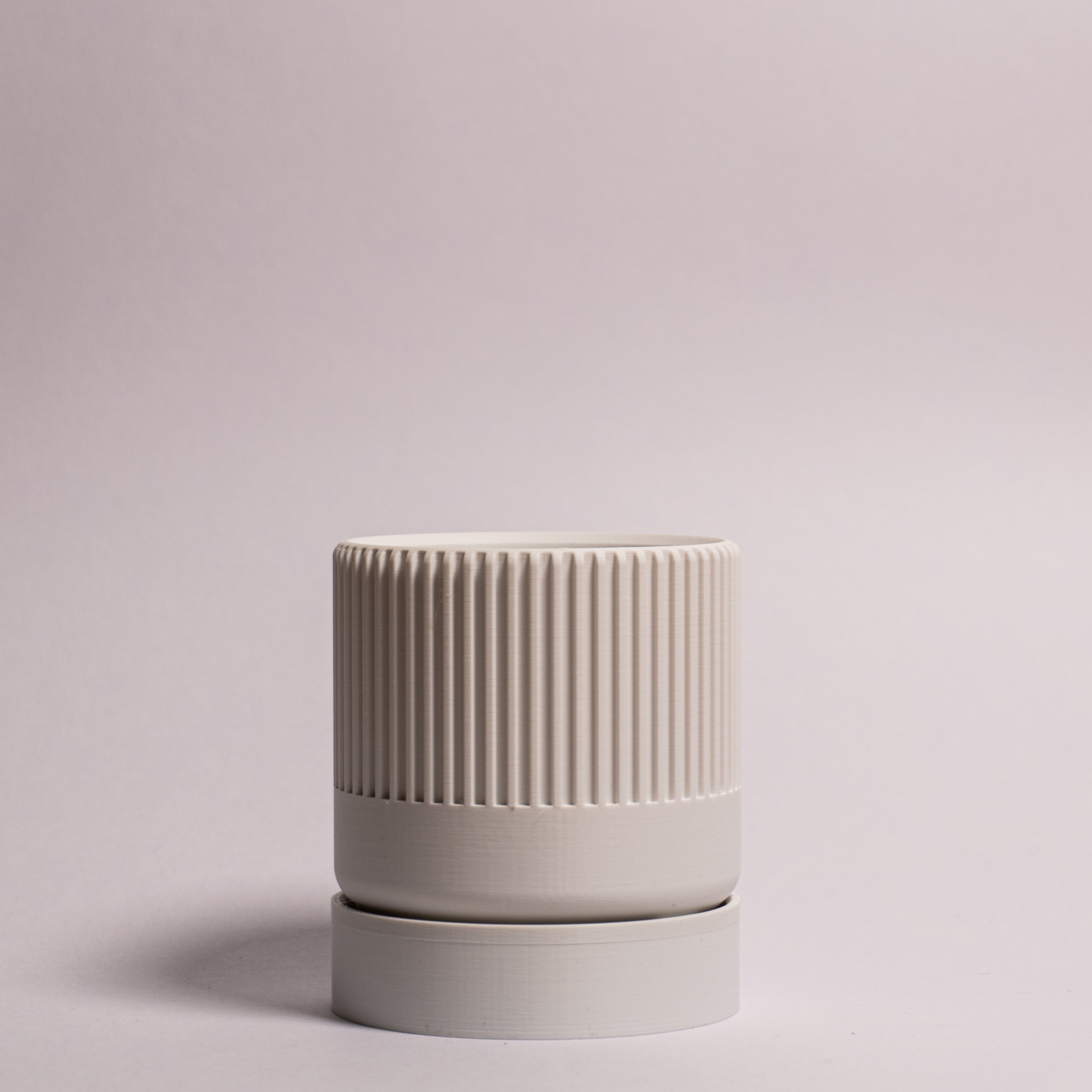 Billede af en hvid Seedling urtepotteskjuler Ø6cm stående oprejst i en ren billedboks med hvid baggrund. Viser minimalistisk design i bioplast.