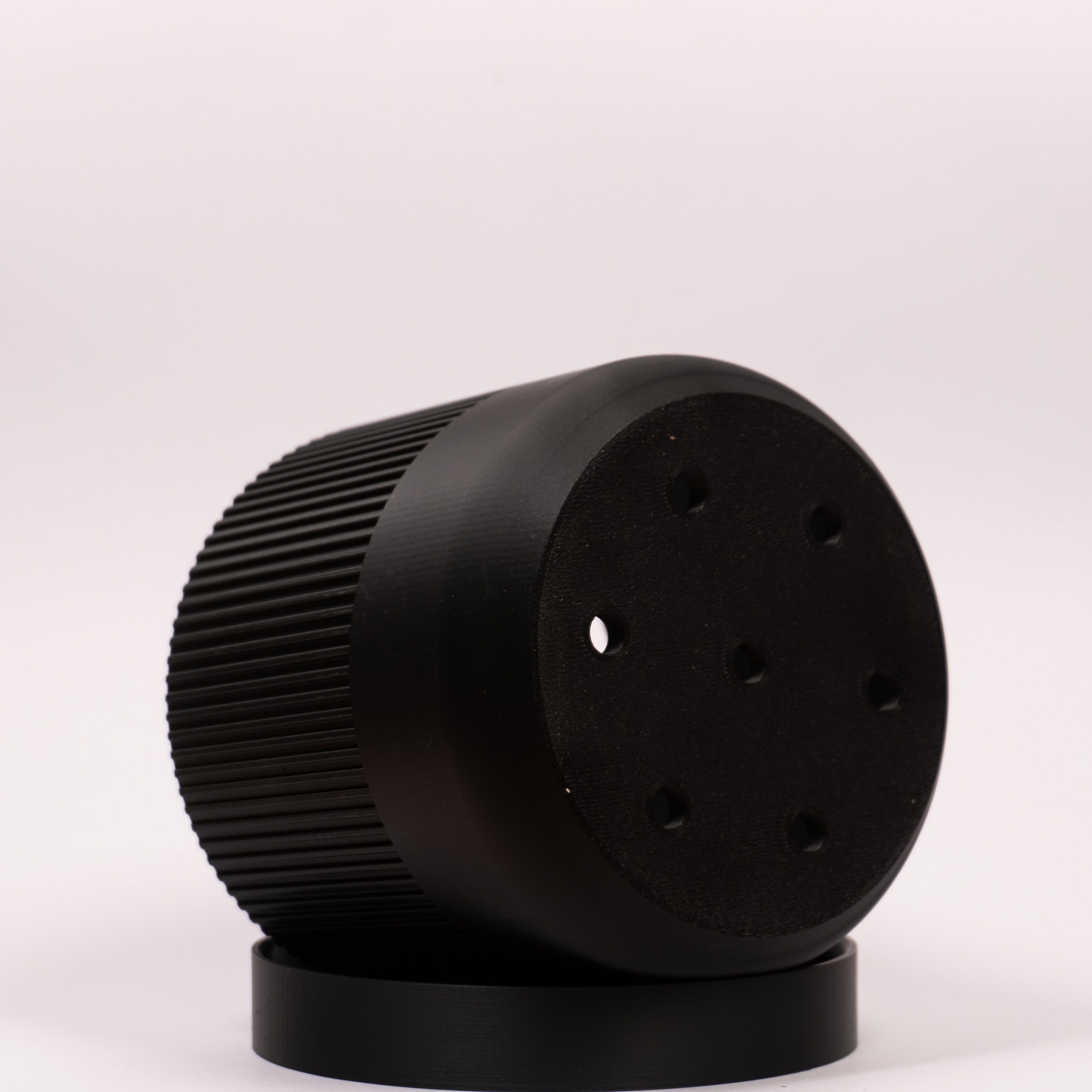 Billede af en Ø11cm sort seedling urtepotteskjuler i sort der viser drænhullerne i bunden med en hvid baggrund