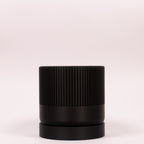 Stilfuld sort Seedling urtepotteskjuler Ø9cm. Billedet er taget i en lys, minimalistisk opstilling, der fremhæver designets kontrast.