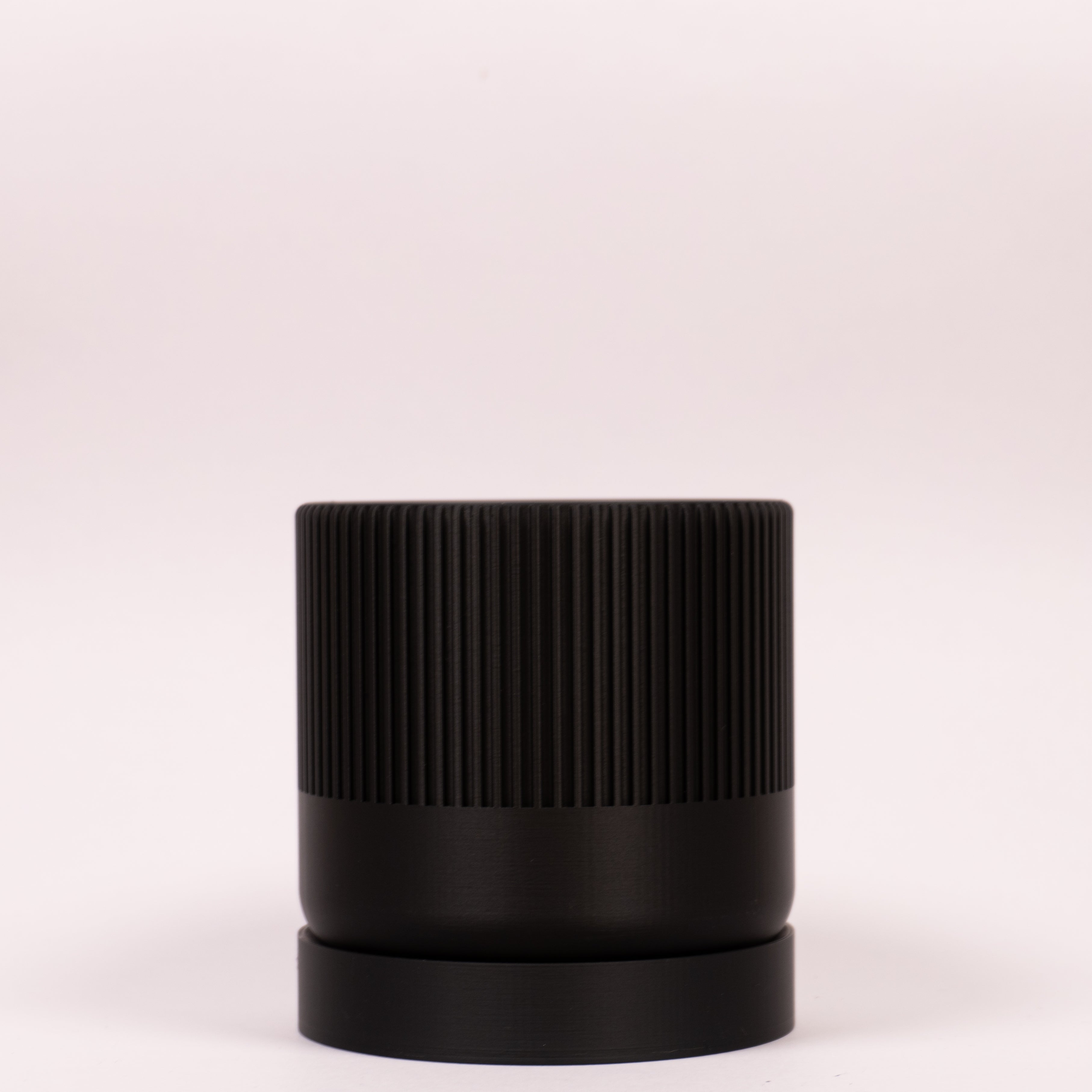 Stilfuld sort Seedling urtepotteskjuler Ø9cm. Billedet er taget i en lys, minimalistisk opstilling, der fremhæver designets kontrast.